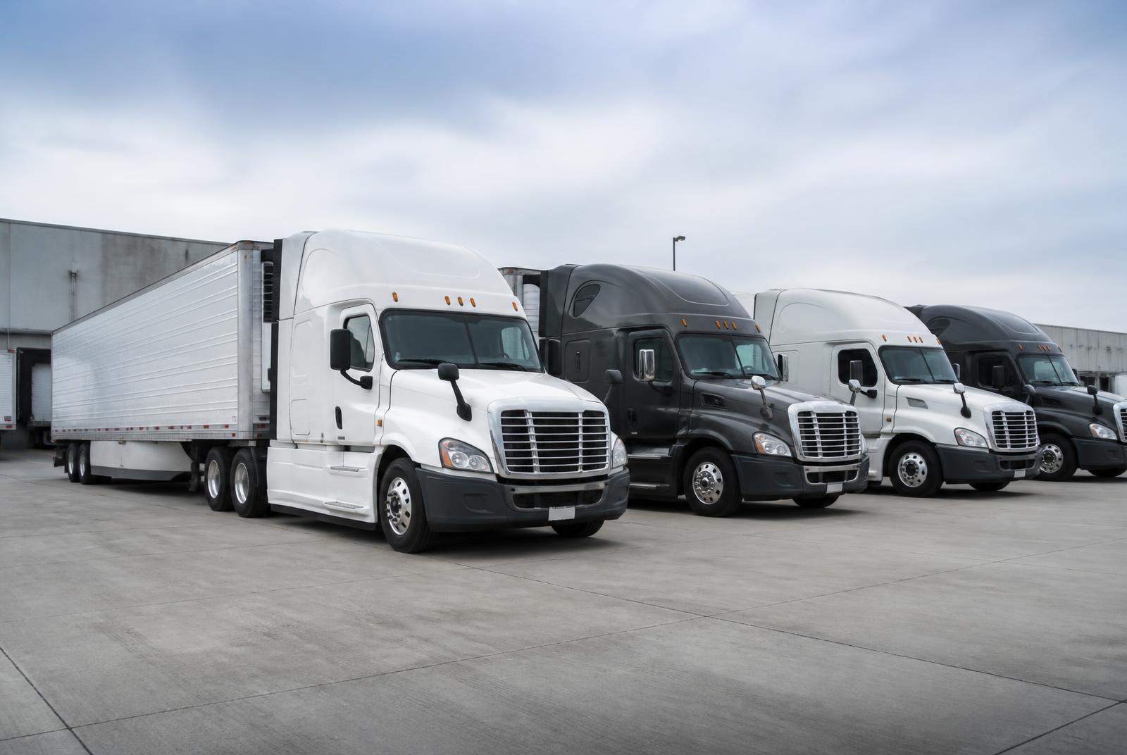 Commercial semi-truck fleet lined up at a logistics yard